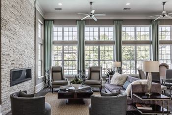 A living room with large windows and a couch and chairs